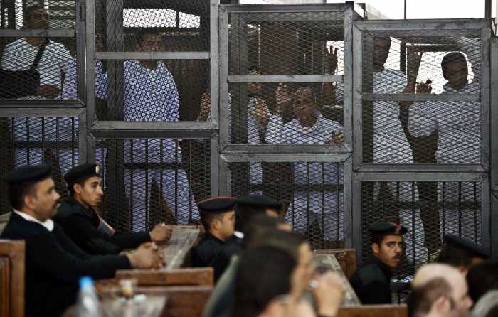 En esta imagen de archivo de mayo de 2014, de Mohamed Fahmy, egipcio-canadiense jefe en funciones de la oficina cariota de Al-Jazeera, el corresponsal australiano Peter Greste y el productor egipcio Baher Mohamed en la jaula de los acusados junto con otros acusados en su juicio en El Cairo FILE / AP PHOTO