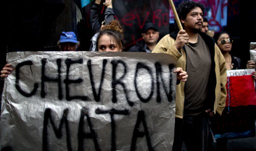 Una manifestante sostiene una pancarta en una manifestación contra un acuerdo de la YPG argentina y la petrolera estadounidense Chevron, en Buenos Aires, Argentina, el miércoles 28 de agosto de 2013. (AP Photo/Natacha Pisarenko)