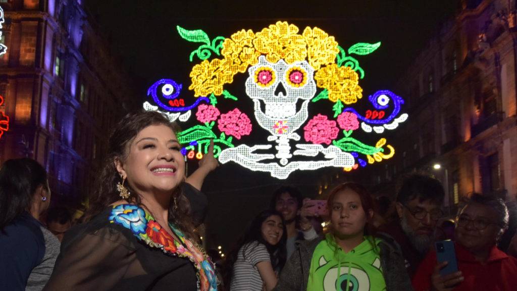 La ofrenda “Procesión” cuenta con 21 calacas de cartonería y un altar de 17 metros, acompañada por un impresionante alumbrado decorativo.